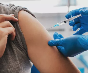 professionnel de santé en train de vacciner un adulte
