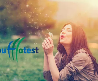 femme soufflant sur un pissenlit